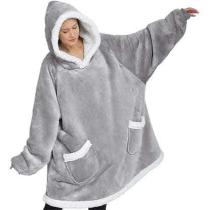 Person wearing a gray hooded poncho with white trim on a white background