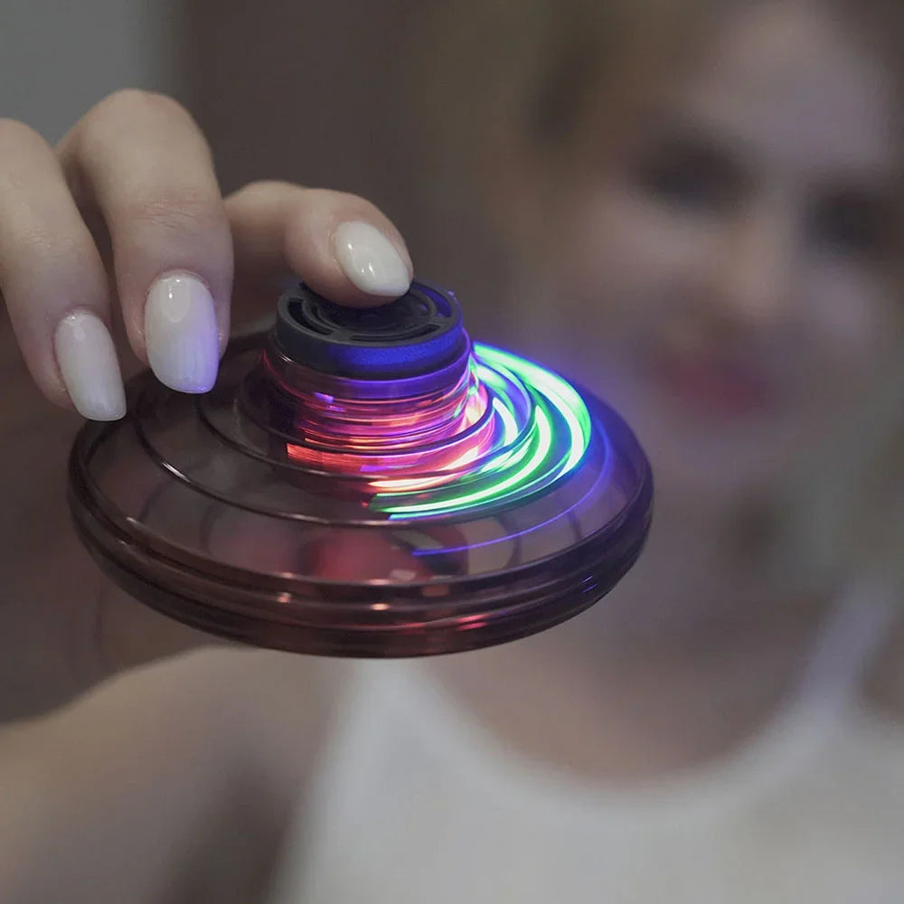 Hand holding a colorful LED spinner with a blurred background