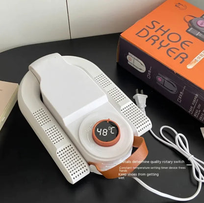 White shoe dryer with digital display on a black surface, next to its packaging box.